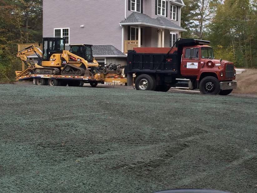 Parker trucks and compact equipment staged beside a newly prepared residential lot